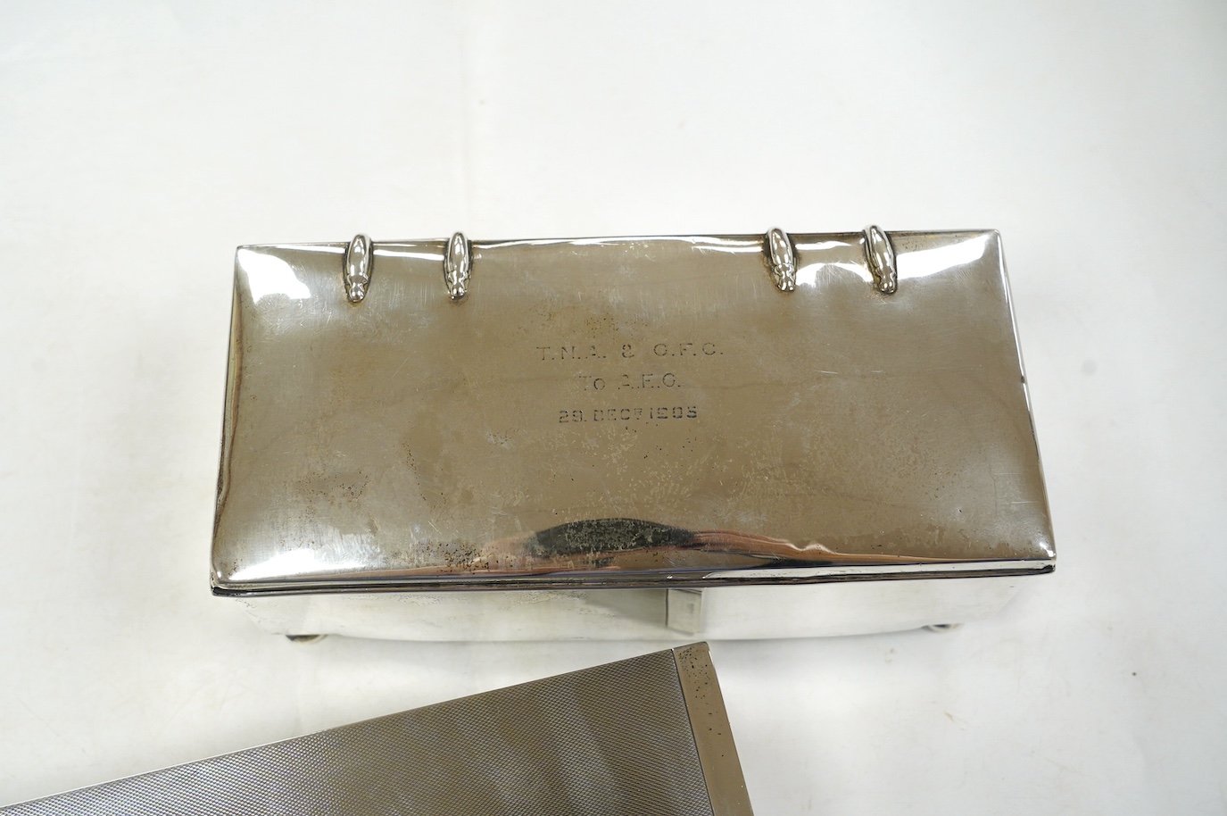 A George V engine turned silver cigarette box, by Padgett & Braham Ltd, London, 1935, 21.6cm and an earlier Irish silver cigarette box. Condition - poor to fair